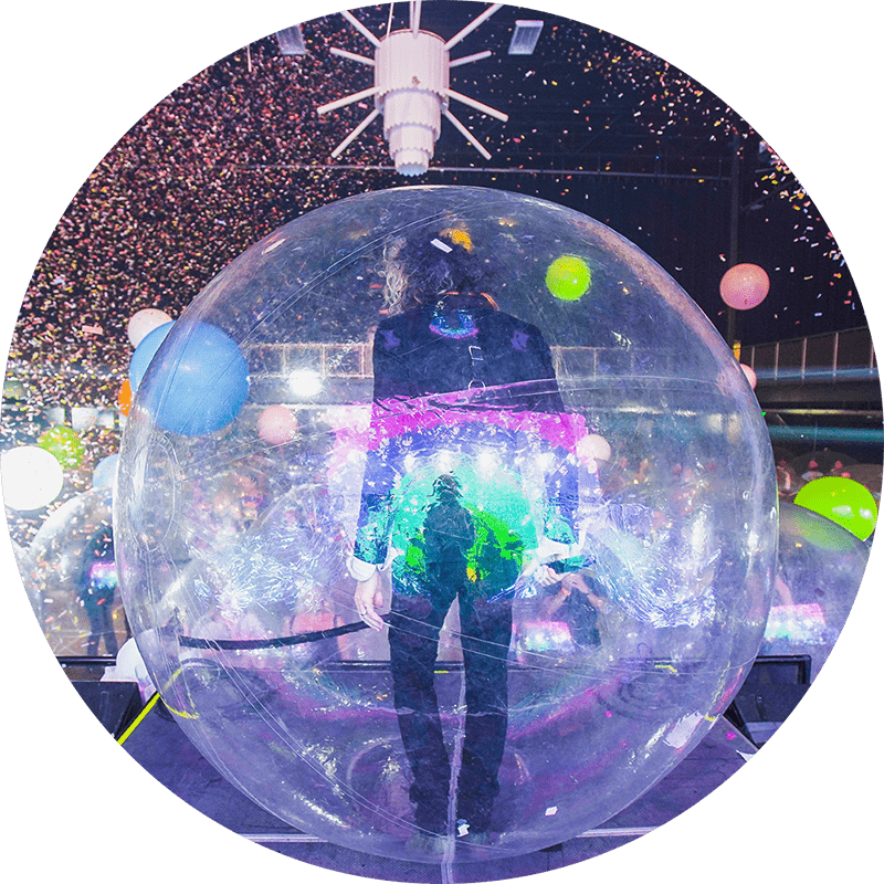 A performer on stage inside an inflatable sphere